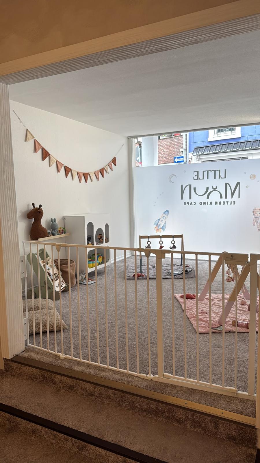 Abgetrennter Babybereich mit Spielbogen, Kuscheltieren und Space-Motiv